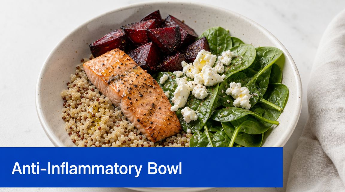 A healthy bowl featuring salmon, quinoa, spinach, roasted beets, and feta cheese on a light surface.