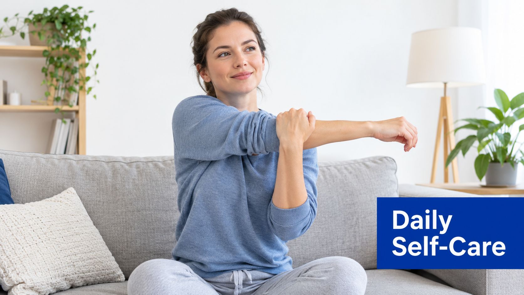 A woman sits on a grey couch stretching her arm, representing daily self-care for muscle health.